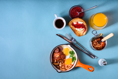 English breakfast with coffee, orange juice and toast. Top view, copy space, blue background.の写真素材