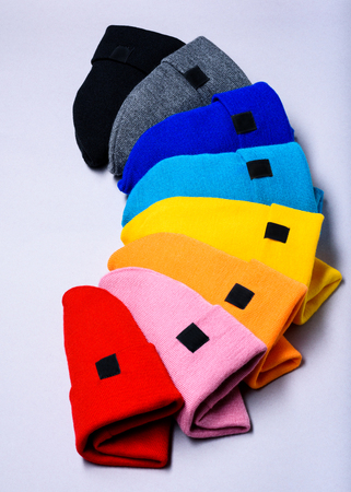 Knitted beanie hats. Colorful clothes items. Top view, copy space. Advertising discount mock up.