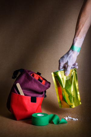 Climbing sport equipment. Chalk, magnesium, bag and plaster roll. A persons hand holding a pack with chalk.の写真素材