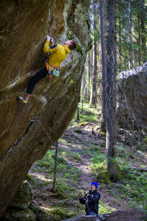 Rock climber ascending a challenging cliff. Extreme sport climbing. Freedom, risk, challenge, success. Sport and active life concept.の写真素材