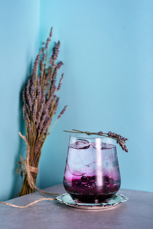 Soda water drink with blueberries and lavender. Cold refreshing beverage on bar counter.の写真素材