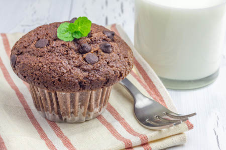 Delicious chocolate muffin with choco chips and glass of milk closeupの写真素材