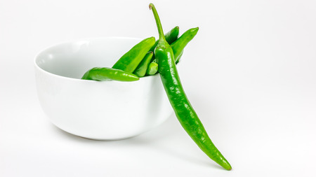 Green chili pepper in the bowl, isolated on the white backgroundの写真素材