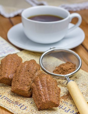 Cocoa powdered choco madeleines with a cup of coffeeの写真素材