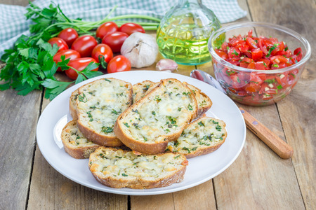 Making tomato bruschetta: garlic cheese crostini and chopped tomatoes with herbsの写真素材