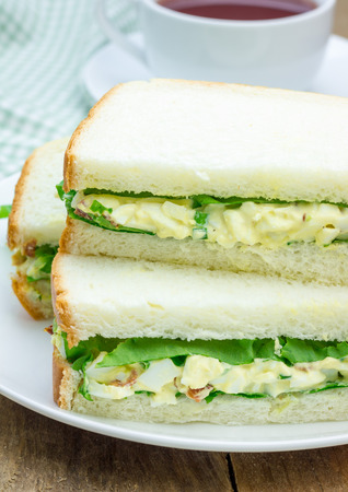 Sandwich with egg salad, bacon, green onion and lettuceの写真素材