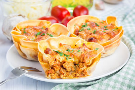 Homemade lasagna cups with minced meat, bolognese sauce topped with cheeseの写真素材