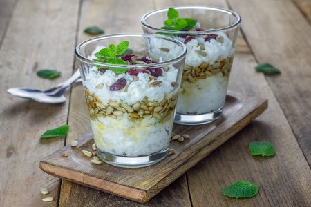 Ricotta cheese dessert with honey, sunflower seeds and mint, garnished with dry cranberriesの写真素材
