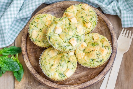 Snack muffins with spinach and feta cheese on a wooden plateの写真素材