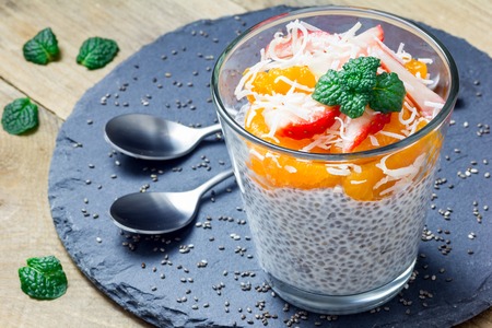 Chia seed pudding garnished with strawberries, mandarins and coconut slicesの写真素材