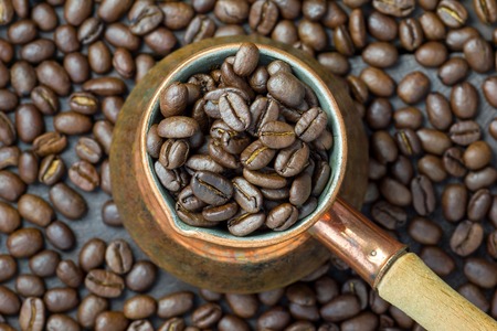 Fragrant coffee beans in copper cezve, top view, close upの写真素材