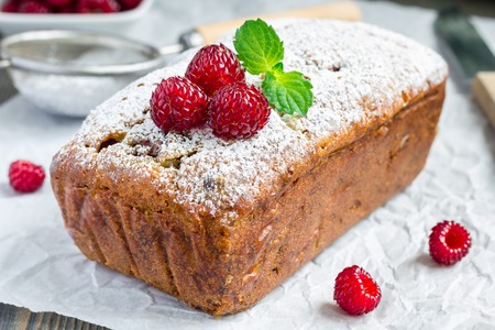 Banana bread with raspberries, cherries and white chocolate on parchment, horizontalの写真素材