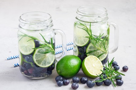 Healthy cold infused water with fresh blueberry, lime and rosemary, horizontalの写真素材