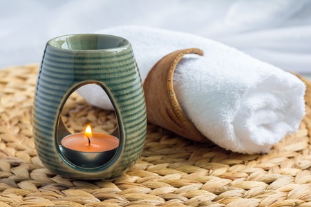 Aroma lamp with grapefruit essential oil on woven mat, spa background, horizontalの写真素材