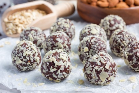 Healthy homemade paleo chocolate energy balls with rolled oats, nuts, dates and chia seeds,...