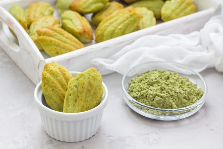 Homemade matcha green tea madeleines on the table and in wooden tray, horizontalの写真素材