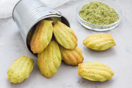 Homemade matcha green tea madeleines on the table and in metal bucket, horizontalの写真素材