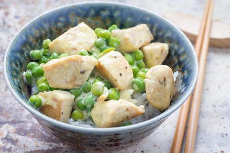 Fried chicken with green peas in cream sauce, served with rice, horizontal, closeupの写真素材