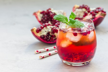 Mojito cocktail with pomegranate, mint, lemon juice and ice in glass, horizontal, copy spaceの写真素材