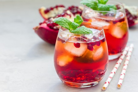 Mojito cocktail with pomegranate, mint, lemon juice and ice in glass, horizontal, copy spaceの写真素材
