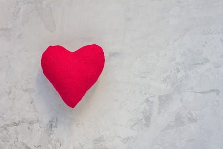 Handmade textile red heart on gray concrete backgroundの写真素材