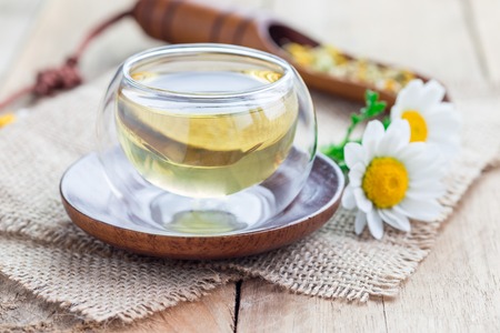 Chamomile tea in glass cup, chamomile flowers and dry tea on background, horizontalの写真素材