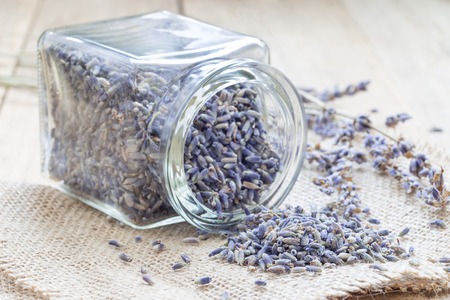 Dry lavender tea in glass jag and on wooden background, horizontalの写真素材