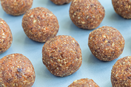 Healthy homemade paleo energy balls with carrot, nuts, dates and coconut flakes, on tray, horizontalの写真素材