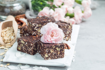Paleo chocolate energy bars with rolled oats, pecan nuts, dates, chia seeds and coconut flakes, horizontal, copy spaceの写真素材