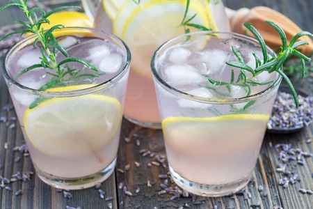 Homemade lemonade with lavender, fresh lemons and rosemary on wooden background, horizontalの写真素材