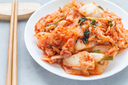 Kimchi cabbage. Korean appetizer on a white plate, horizontal, closeupの写真素材