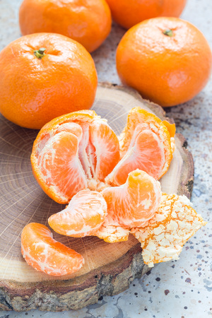 Aromatic ripe mandarins laying on a wooden log, verticalの写真素材