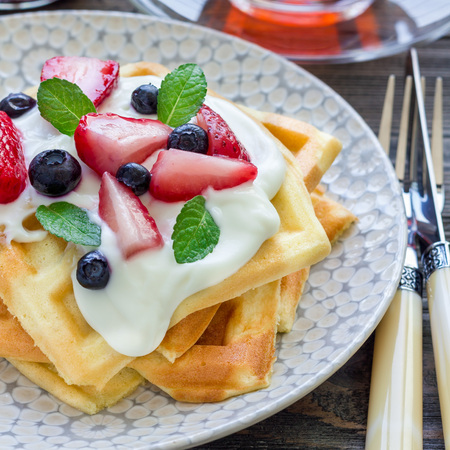 Homemade belgian waffles with yogurt, strawberry and blueberry, breakfast time, square formatの写真素材