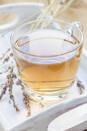 Healthy herbal lavender tea in a glass cup with lavender flowers on background, verticalの写真素材