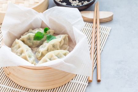 Steamed Korean dumplings Mandu with chicken meat and vegetables in a bamboo steamer, horizontal, copy spaceの写真素材