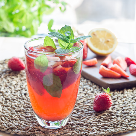 Homemade iced tea with strawberries and mint on a wooden table, square formatの写真素材