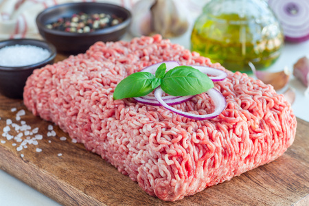 Minced meat from pork and beef. Ground meat with ingredients for cooking on a wooden board,...