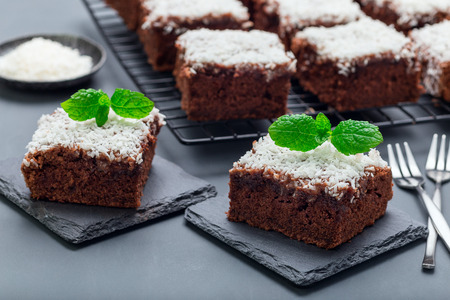 Homemade brownie with coconut flakes, swedish dessert Karleksmums, cut in square servings, on a stone plate, horizontalの写真素材