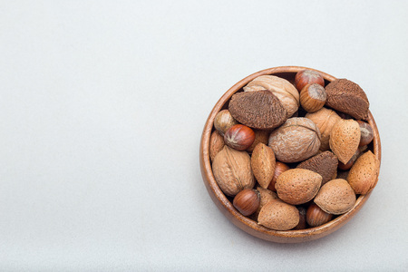 Hazelnut, walnut, almond and brazil nuts in a wooden bowl, horizontal, copy spaceの写真素材