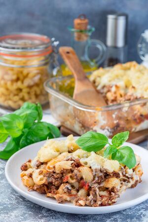 Macaroni casserole with ground beef, cheese and tomato on a plate, verticalの写真素材