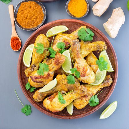 Indian chicken tandoori, marinated in greek yogurt  and spices, served with lime wedges and cilantro, top view, square formatの写真素材
