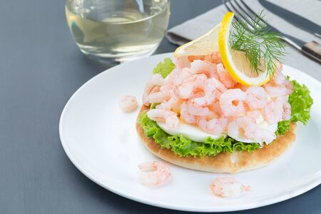 Traditional savory swedish sandwich with soft white bread vetekaka, lettuce, eggs, mayonnaise, shrimps, dill and lemon, horizontal,  copy spaceの写真素材