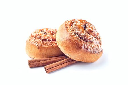Two cinnamon buns and cinnamon sticks isolated on a white backgroundの写真素材