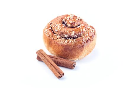 One cinnamon bun and cinnamon sticks isolated on a white backgroundの写真素材