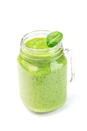 Green detox smoothie with avocado, spinach, cucumber, orange, lemon and honey, in a glass mason jar, vertical, isolated on a whiteの写真素材