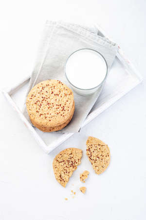 Oatmeal and red quinoa cookies with glass of milk, on a wooden tray, vertical, top viewの写真素材