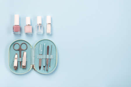 Manicure or pedicure set equipment with nail coat or polish, on a blue background, horizontal, copy space, top viewの写真素材