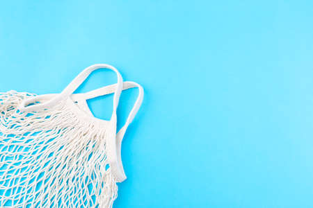 Mesh bag on a blue background, zero waste or plastic free concept, horizontal, top view, copy space
