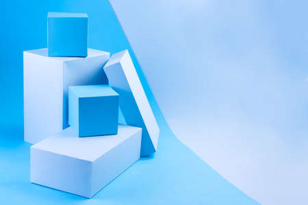 Light and dark blue geometric podiums on a blue background, horizontal, copy spaceの写真素材