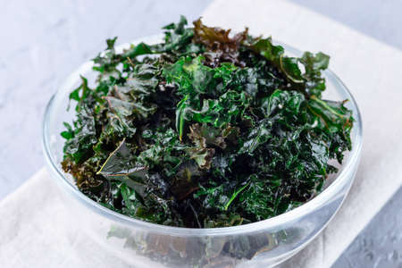 Three ingredient baked green kale chips with sea salt and olive oil, horizontal, closeup